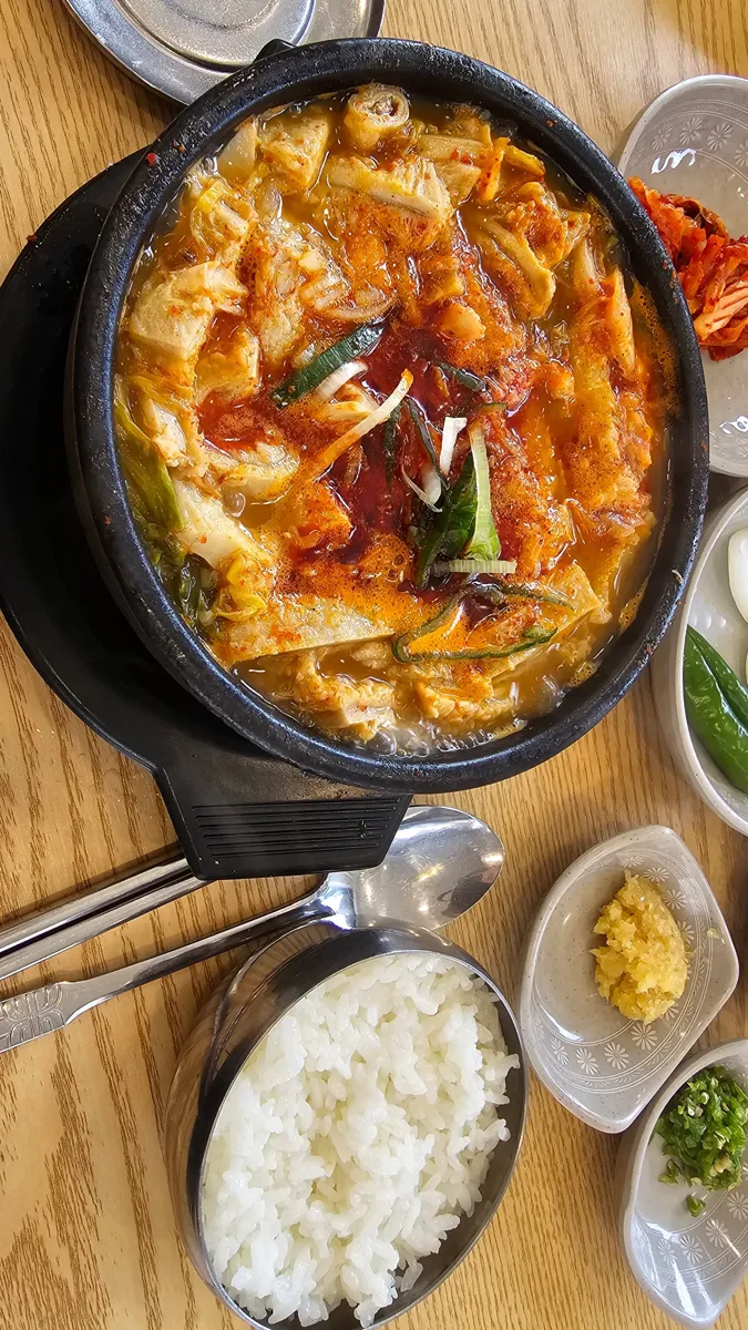 뚝배기에 담긴 얼큰한 매운탕과 공깃밥, 반찬