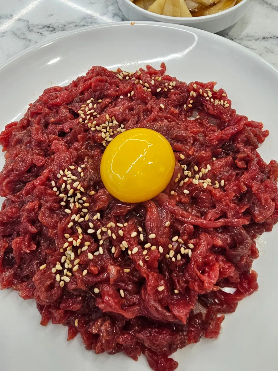 참깨와 노른자를 올린 붉은 육회 한 접시